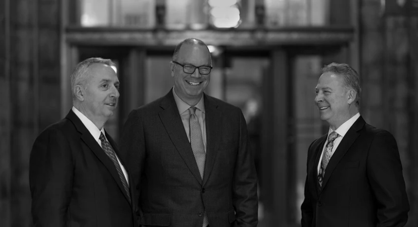 Sakkas, Cahn & Weiss personal injury lawyers standing together indoors.